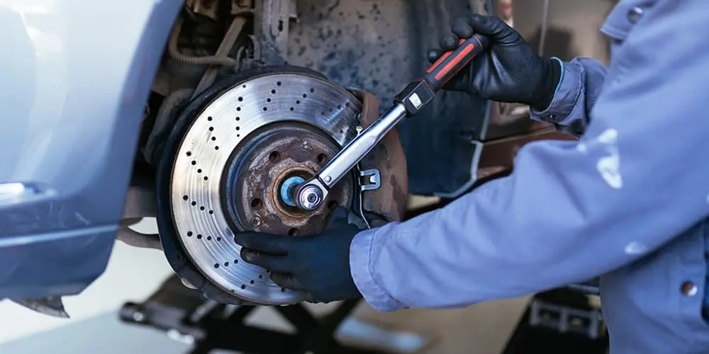 Photo Of Mechanic Working On Brakes